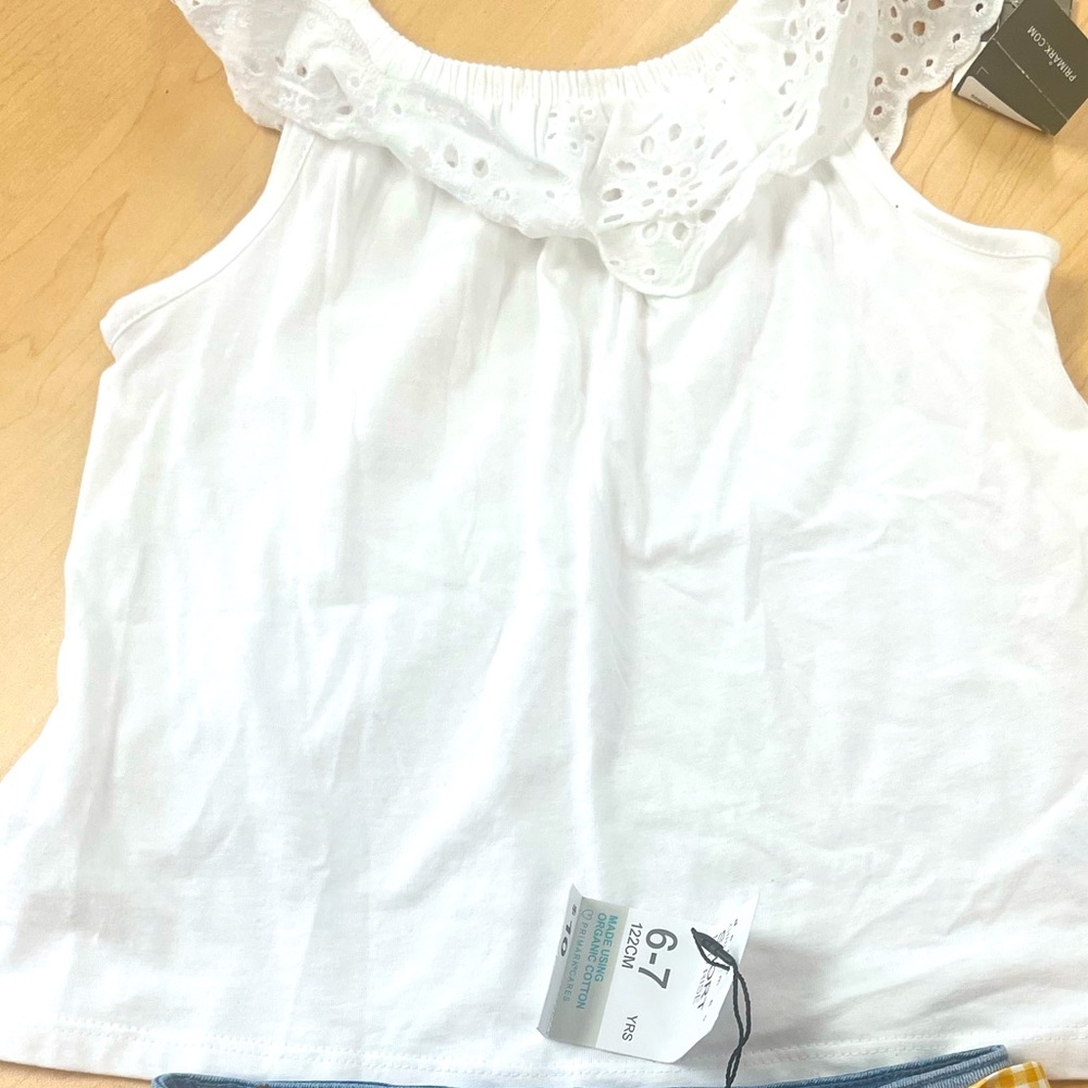 On Whitt no sleeve summer shirt along with Jean blue shorts with a yellow belt.